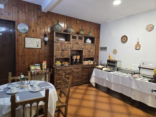 a restaurant with two tables and a counter with food at Hosteria Picos De Europa in Potes