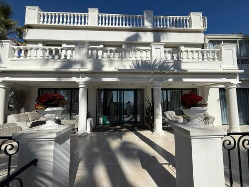 un manoir blanc avec un balcon au-dessus dans l'établissement Luxury villa face to the sea - swimming pool, à Cannes