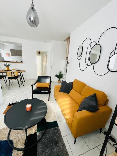 un salon avec un canapé jaune et une table dans l'établissement Cambrai Cosy Home, à Cambrai