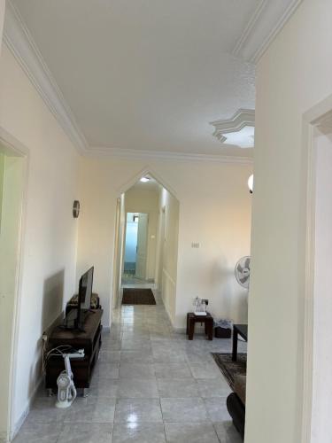 a living room with a piano and a hallway at Furnished Family Apartment in Dahyet Al-Rasheed in Amman