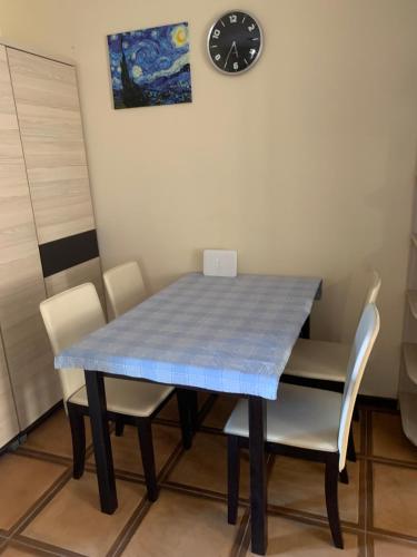 a blue table with chairs and a clock on the wall at Apartments Matjia in Donji Stoliv
