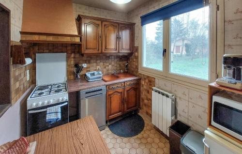 a small kitchen with wooden cabinets and a window at 2 Bedroom Amazing Home In Montliard in Montliard