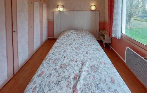 a bed in a room with a floral blanket on it at 2 Bedroom Amazing Home In Montliard in Montliard