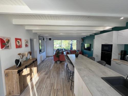 - une cuisine et un salon avec un grand comptoir dans l'établissement Maison 4 chambres & jardin à Chéray, à Saint-Georges-dʼOléron