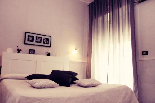 a bedroom with a bed with two pillows and a window at Hotel Luna Rossa in Naples