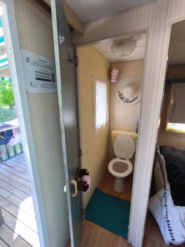 Cette petite chambre comprend une petite salle de bains pourvue de toilettes. dans l'établissement Mobil home Kermit côté atantique royan 17 camping 3 étoiles, à Breuillet