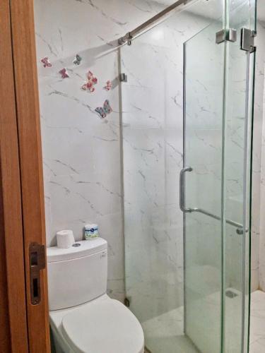 a bathroom with a toilet and a glass shower at TMS Quy Nhơn - Có Ban Công Và Tầm Nhìn Biển, Phù Hợp Với Gia Đình Có Bếp in Quy Nhon