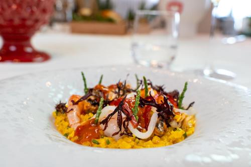 a white plate with food on a table at Grand Hotel Faraglioni in Acitrezza