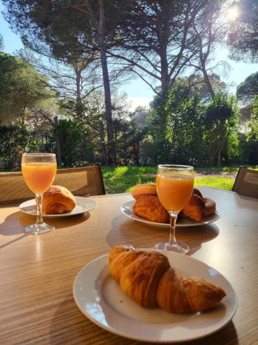 - une table avec deux verres de jus d'orange et des croissants dans l'établissement Perfect holidays, à Saint-Raphaël