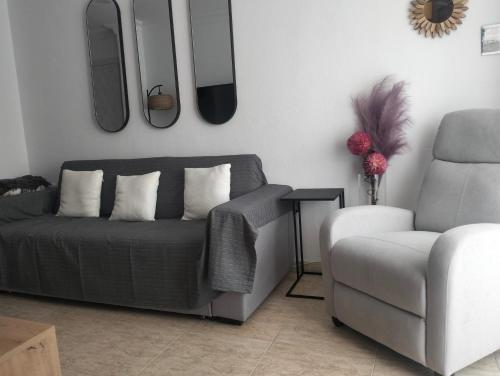 a living room with a couch and a chair at La Cabaña de La Antilla in Huelva
