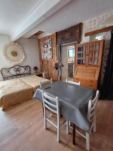 une chambre avec un lit, une table et des chaises dans l'établissement Le toit du monde, à Ceyreste
