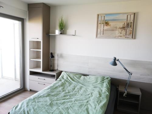 une chambre avec un lit, une lampe et une fenêtre dans l'établissement Apartment with sea views, à Berck-sur-Mer