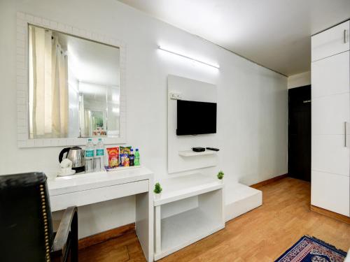 Un baño blanco con lavabo y espejo. en Hotel Sweet Home Lodge - 2 min from New Delhi Railway Station, en Nueva Delhi