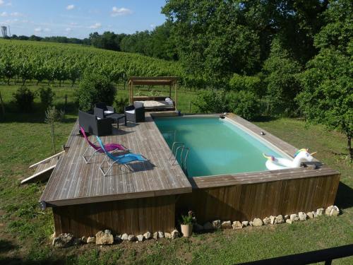 une piscine avec une terrasse en bois et un cygne dessus dans l'établissement Gîte de Bossugan, à Bossugan