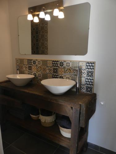 une salle de bain avec deux lavabos et un miroir dans l'établissement Gîte de Bossugan, à Bossugan