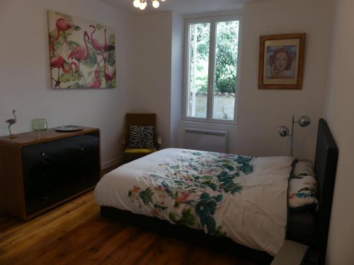 une chambre avec un lit, une télévision et une fenêtre dans l'établissement Gîte de Bossugan, à Bossugan