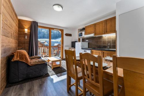 une cuisine et un salon avec une table et des chaises dans l'établissement Les Chalets De Bois MÉan - A - Chaleureux duplex pour 6 personnes aux Orres 1800 MAE-4581, aux Orres