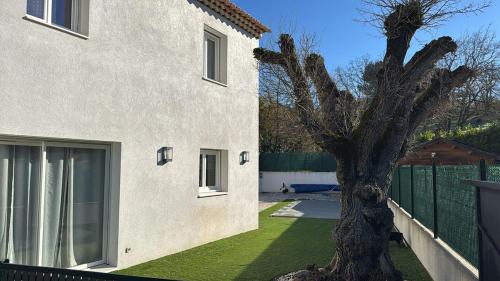 a house with a tree in the yard at Maison avec piscine en provence in Fuveau
