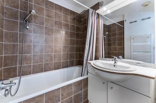 une salle de bain avec une baignoire et un lavabo et une baignoire dans l'établissement Les Chalets De Bois MÉan - A - Chaleureux duplex pour 6 personnes aux Orres 1800 MAE-4581, aux Orres