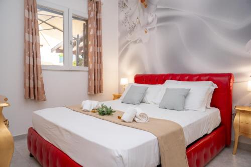 a bedroom with a red bed with towels on it at Dimora Cavallo a 150m da spiaggia sabbiosa in Torre Santa Sabina