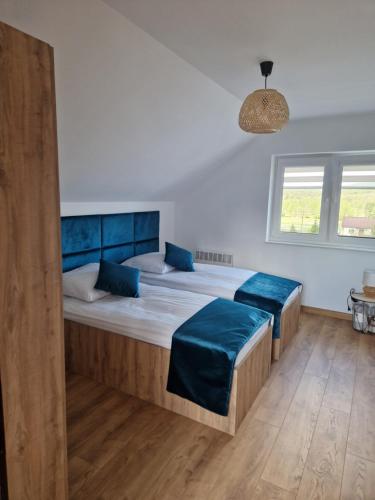a bedroom with two beds with blue pillows at Domy na Roztoczu Aleja Lipowa B,G,J,K Sauna Jacuzzi Kajaki in Zwierzyniec