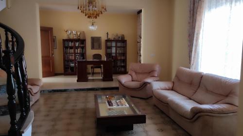 a living room with a couch and chairs and a table at Cora Manna casa vacanze in Càbras