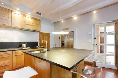 une cuisine avec des placards en bois et un grand îlot dans l'établissement Countryside Villa Provence - Pool Tennis & horses, à Saint-Cannat