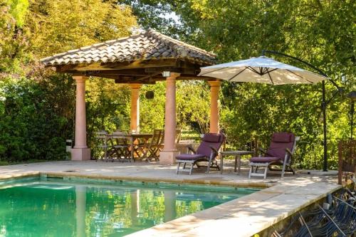 - un pavillon avec des chaises et un parasol à côté de la piscine dans l'établissement Countryside Villa Provence - Pool Tennis & horses, à Saint-Cannat