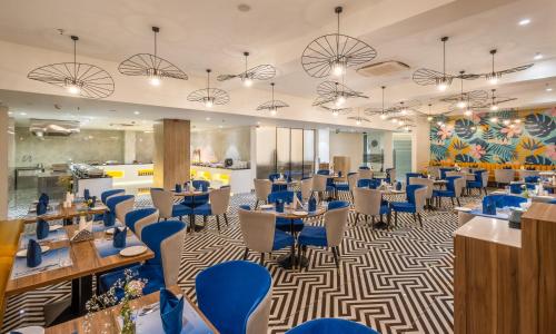 a dining room with tables and blue chairs at Effotel by Sayaji Navi Mumbai in Navi Mumbai