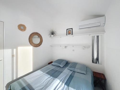 une chambre avec un lit dans une pièce blanche dans l'établissement Appartement Cannes vue sur mer, à Cannes