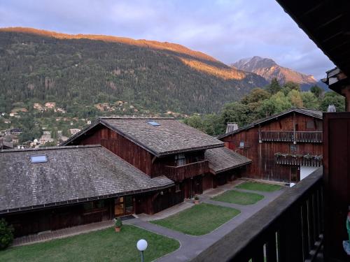 un groupe de bâtiments avec des montagnes en arrière-plan dans l'établissement Au coeur des Alpes, à Saint-Gervais-les-Bains