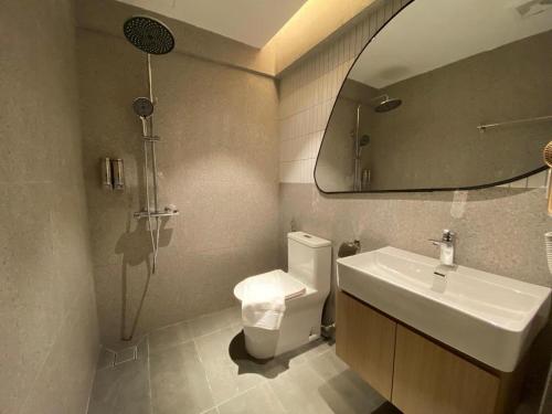 a bathroom with a toilet and a sink and a mirror at 32E Home Sleep Home in Kuah
