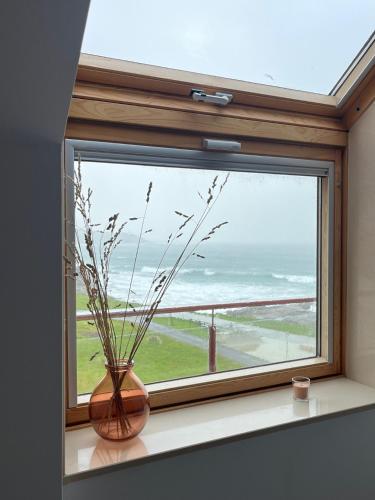 a window with a vase sitting on a window sill at Ático Son do Mar by Cristian&Tamara "alquileres" in Porto do Son