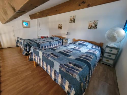 une chambre avec deux lits et une table avec une lampe dans l'établissement Jolie maison d'angle 4 couchages dans résidence privée à 300m de la mer PORTIRAGNES PLAGE LRHP47, à Portiragnes