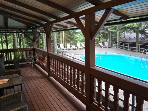 a screened in porch with a swimming pool at Gostynniy Dvir in Forest Коттеджи in Migovo