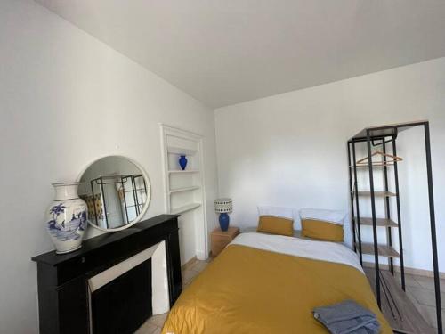 une chambre avec un lit et un miroir au mur dans l'établissement Studio - Hypercentre, à Bourges