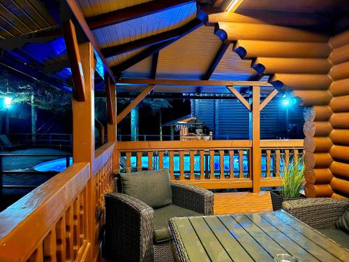 a wooden porch with a wooden table and chairs at Gostynniy Dvir in Forest Коттеджи in Migovo