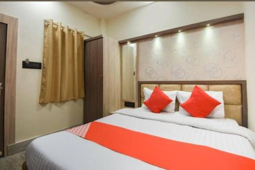 a bedroom with two beds with red pillows at Hotel Eden Park in Nimtita