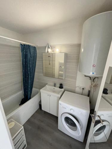 une petite salle de bains avec un lave-linge et un lavabo dans l'établissement Bel Appartement T2 - Résidence Lagon Bleu - Piscine, à Fréjus