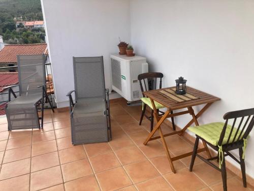 a room with a table and chairs on a balcony at Casa Das Estevas in Vila Velha de Ródão
