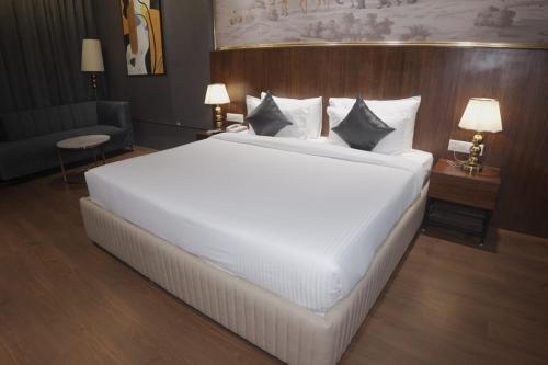 a large white bed in a hotel room at Hotel Pradoe in Bathinda
