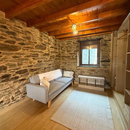ein Wohnzimmer mit einer Couch und einer Steinwand in der Unterkunft A Barreira in Ferrol