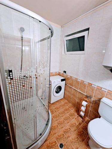 a bathroom with a shower and a washing machine at Chill and sea in Kavarna