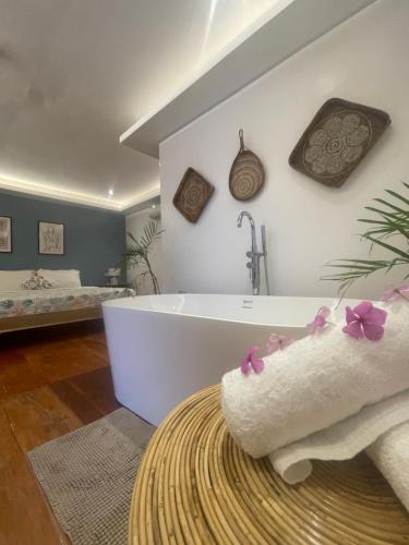 a bathroom with a bath tub and a bedroom at Apoheo Beach Cabin Free Use Motrbike Drng Stay in El Nido