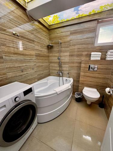 a bathroom with a tub and a washing machine in it at RoApart B2 Home Apartamente 2 și 3 camere terase spațioase vedere si parcare in Năvodari