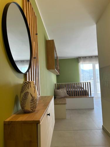 Cette chambre comprend un miroir et une table avec un vase. dans l'établissement Cœur Ajaccio calme plage nature, à Ajaccio