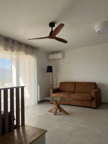 un salon avec un canapé et un ventilateur de plafond dans l'établissement Cœur Ajaccio calme plage nature, à Ajaccio