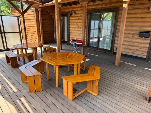 a wooden deck with tables and benches on a cabin at P's Wood 伊豆高原 in Ito