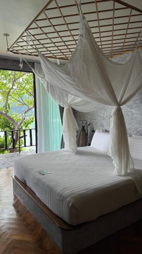 a bedroom with a bed with a mosquito net at Sai Daeng Resort in Koh Tao