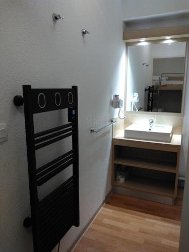une salle de bain avec un lavabo et un miroir dans l'établissement Studio 4 pers, aux Orres